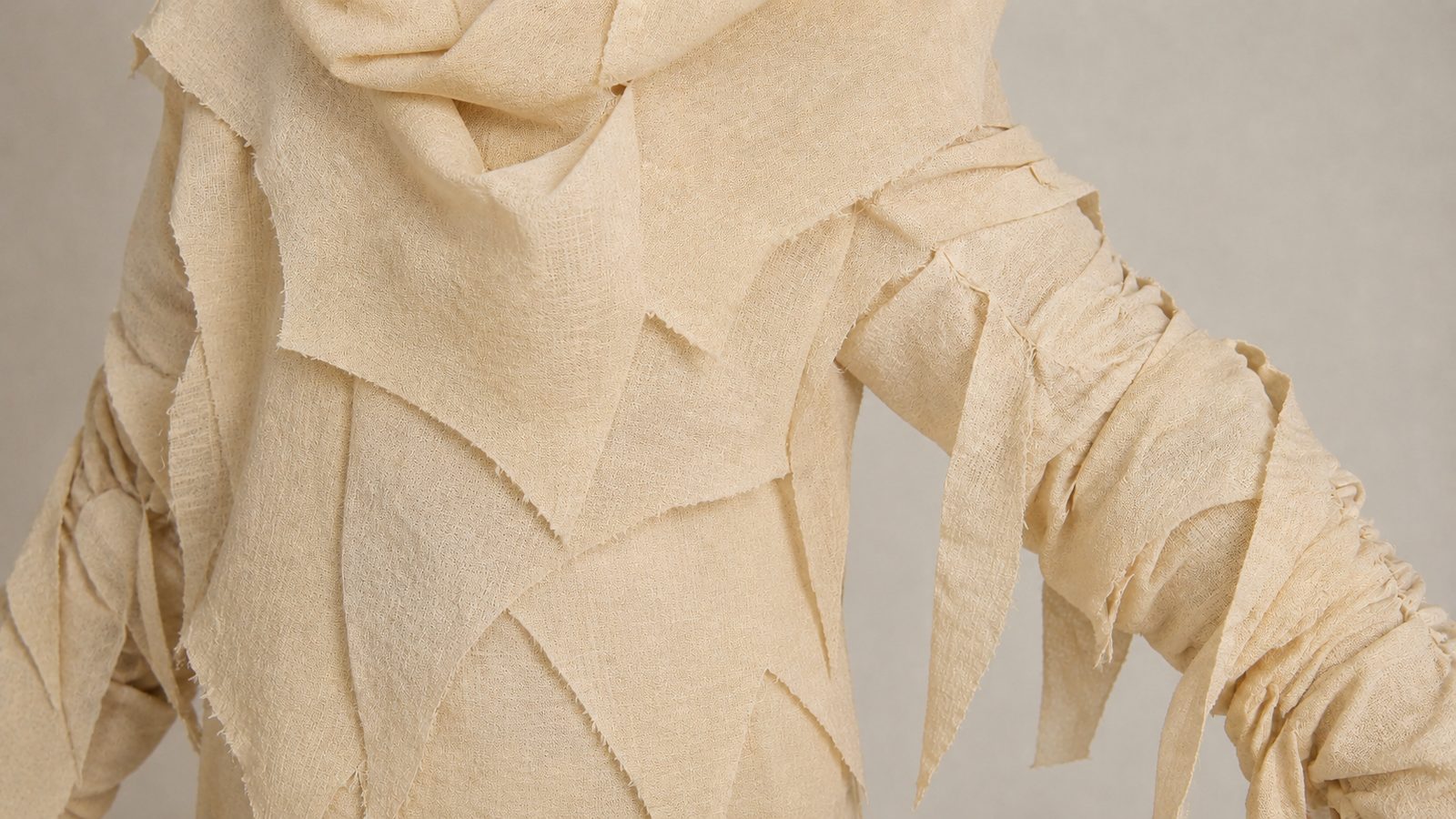 Close-up detail of a kids mummy costume's bandage-print fabric showing full opaque coverage with no see-through gaps