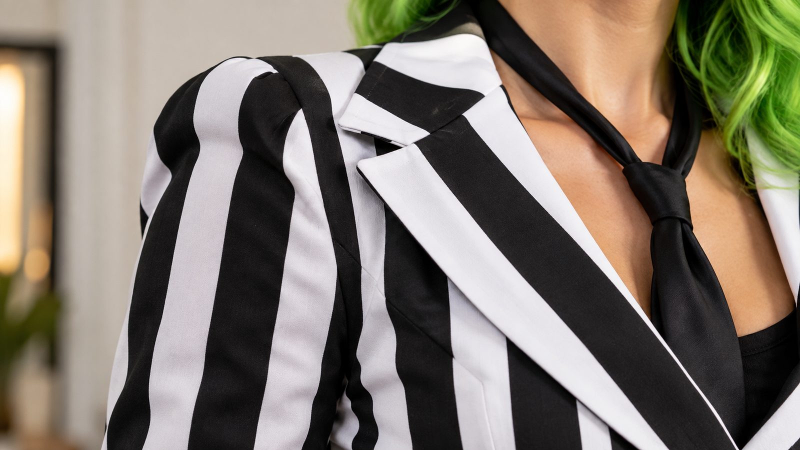 Close-up of a structured shoulder and peplum seam on an 80s monochrome striped power suit costume