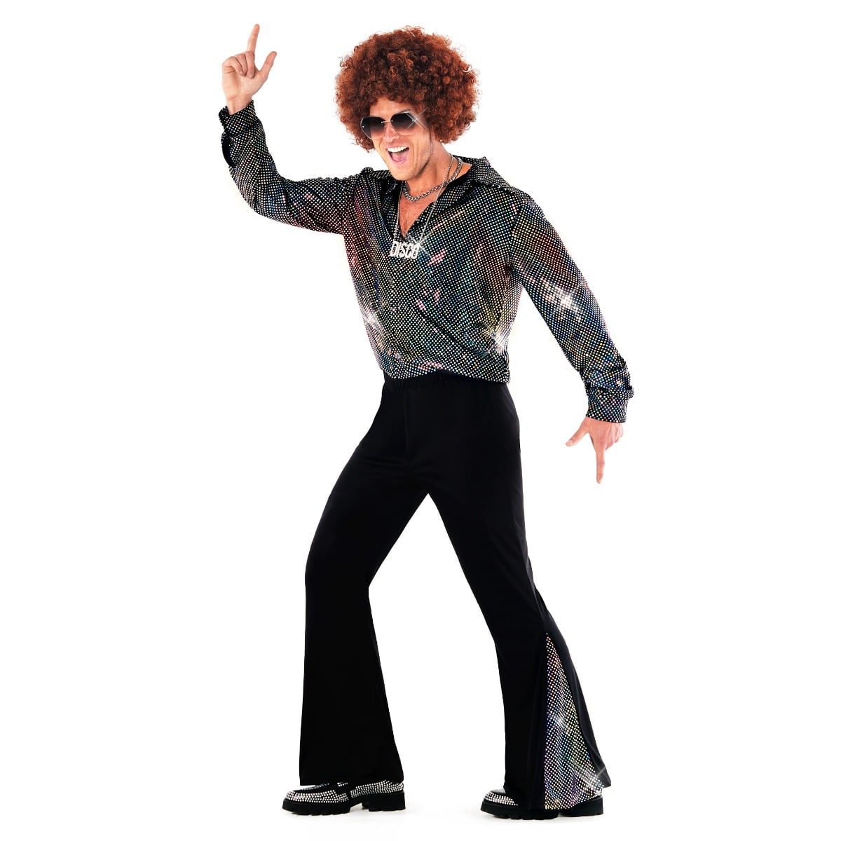 Man wearing an iridescent black shirt covered in multicoloured holographic dots with black flared trousers featuring sparkly sequin inserts, a curly brown wig and aviator sunglasses