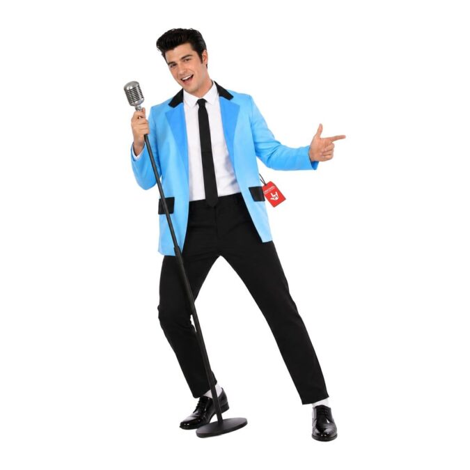 Man in a Teddy Boy costume: light blue jacket with black collar and pocket flaps, black skinny tie, black trousers and white socks, beside a vintage microphone