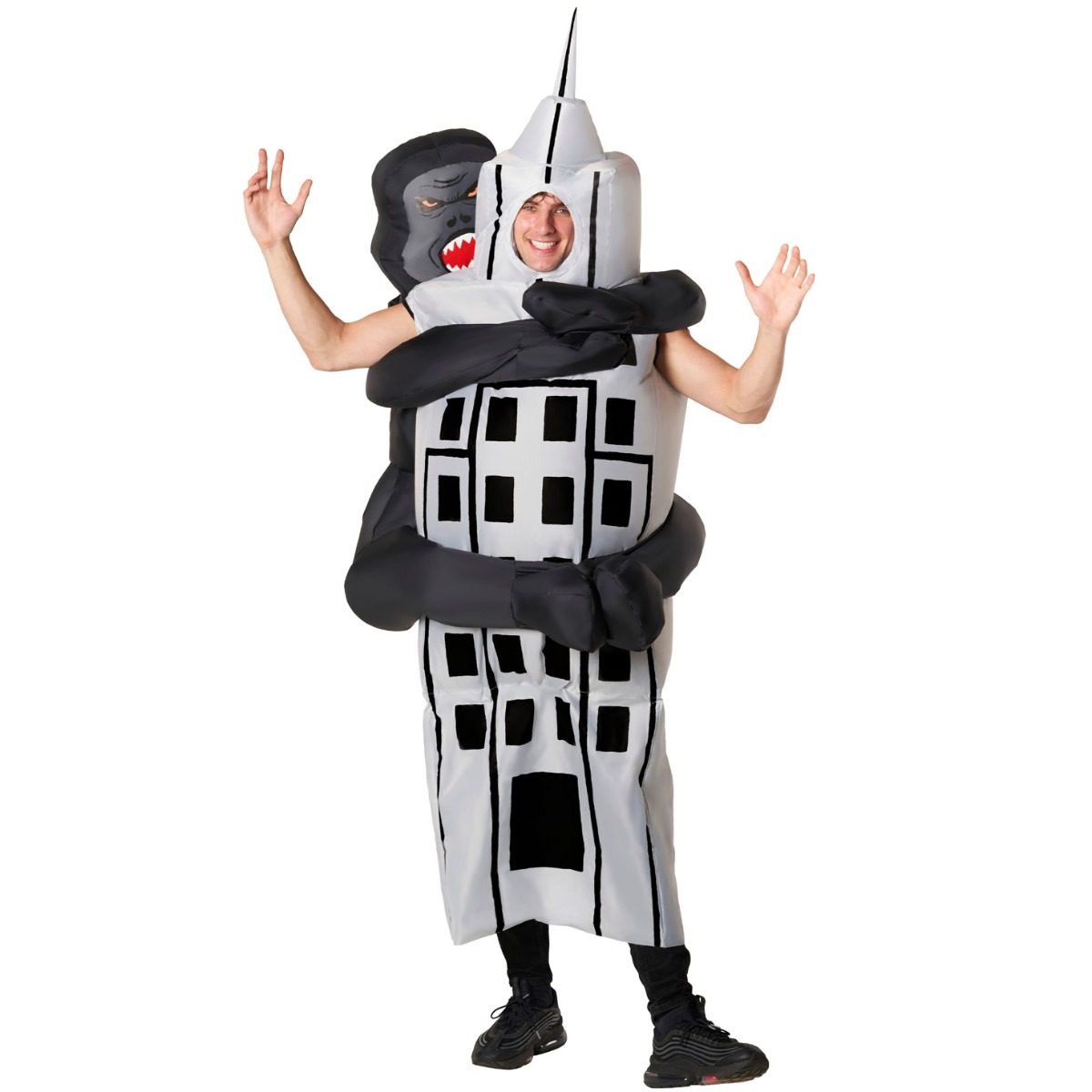 Person wearing an inflatable costume of a black gorilla hugging a white skyscraper, the wearer's face at the top of the building