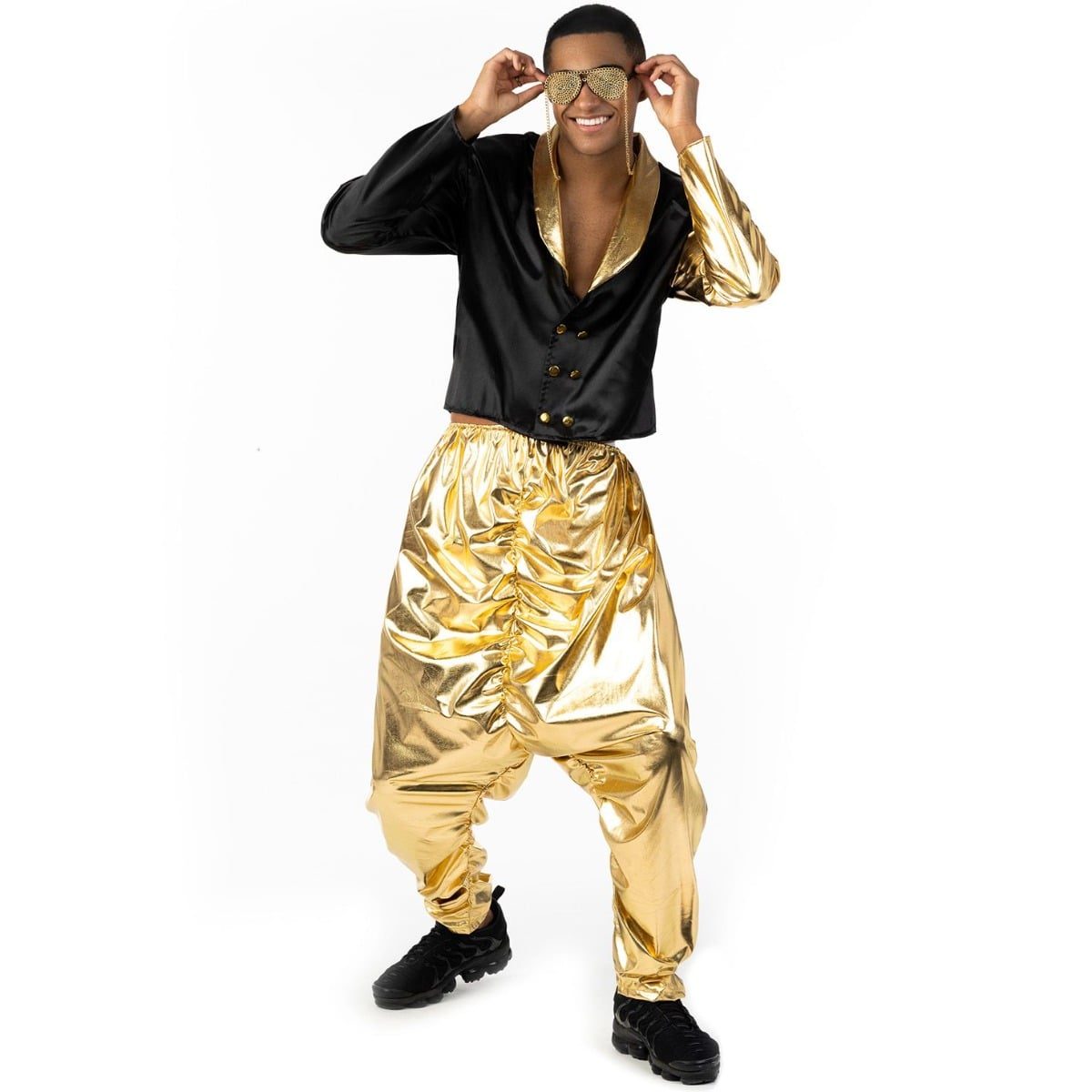 Man in a 1990s rapper costume with a black satin cropped jacket with a gold shawl collar and gold sleeve panels, worn with very baggy gold metallic pants gathered at the ankle