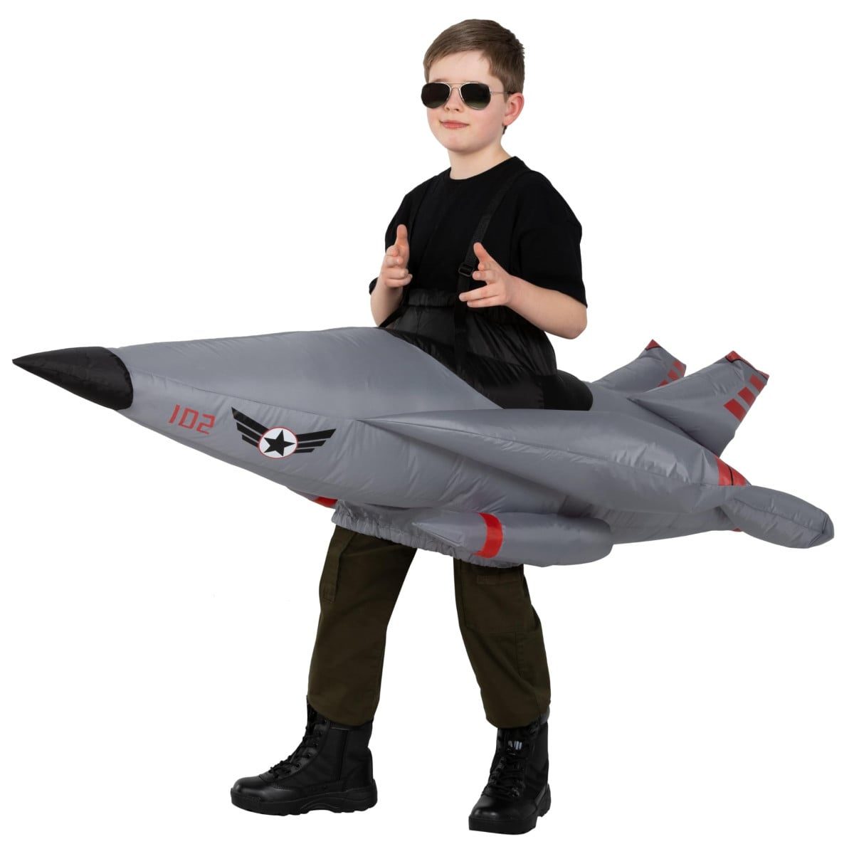 Child wearing a ride-on style inflatable fighter jet Halloween costume in gray with a generic star roundel and tail number, worn over regular clothes with black boots visible underneath