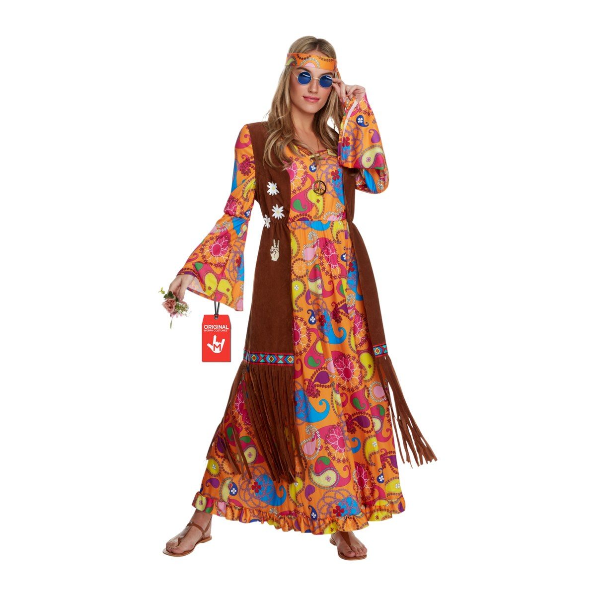 Woman in an orange, pink, and blue paisley long dress with wide bell sleeves, a long brown fringed vest with flower and peace-hand patches, and a printed headband, wearing blue round sunglasses and holding a small flower bouquet