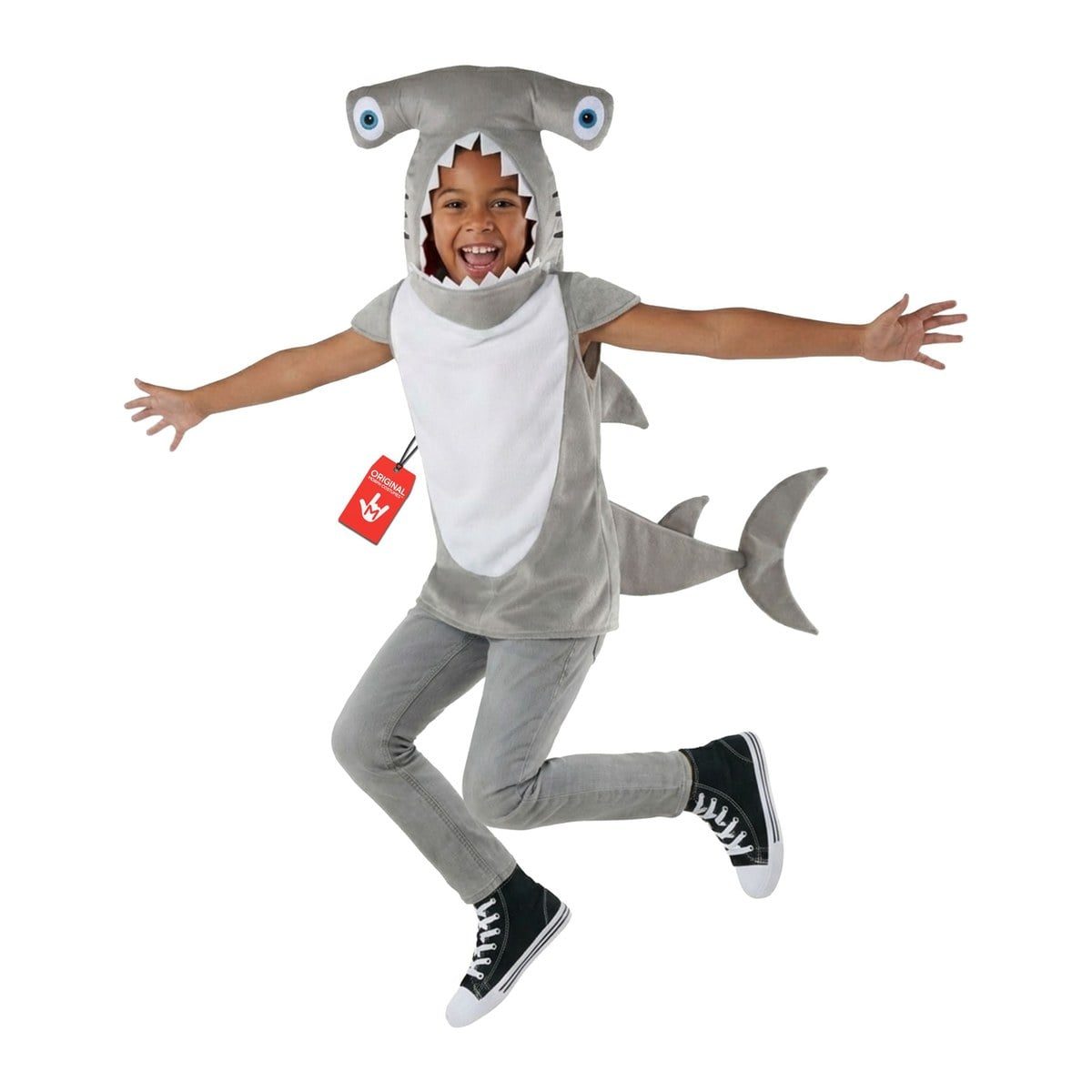 Child leaping in a gray plush hammerhead shark tunic with wide-set blue eyes on the hood, white teeth around the face opening, a white front panel, and a tail, over gray jeans and black sneakers