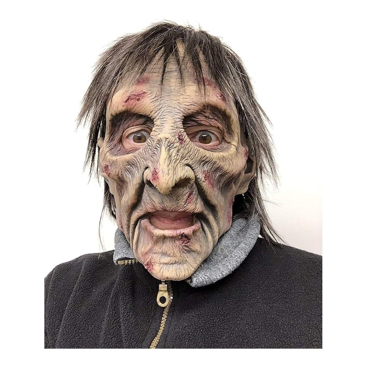 Wrinkled latex zombie mask with sunken eyes, scabbed scratches, an open mouth, and long gray hair, worn with a black fleece jacket
